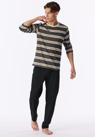 Zwart | sfeer | Op model in ontspannen houding, gestreept shirt en zwarte broek – Schiesser katoenen heren pyjama lange mouw - Zwart - Casual Nightwear