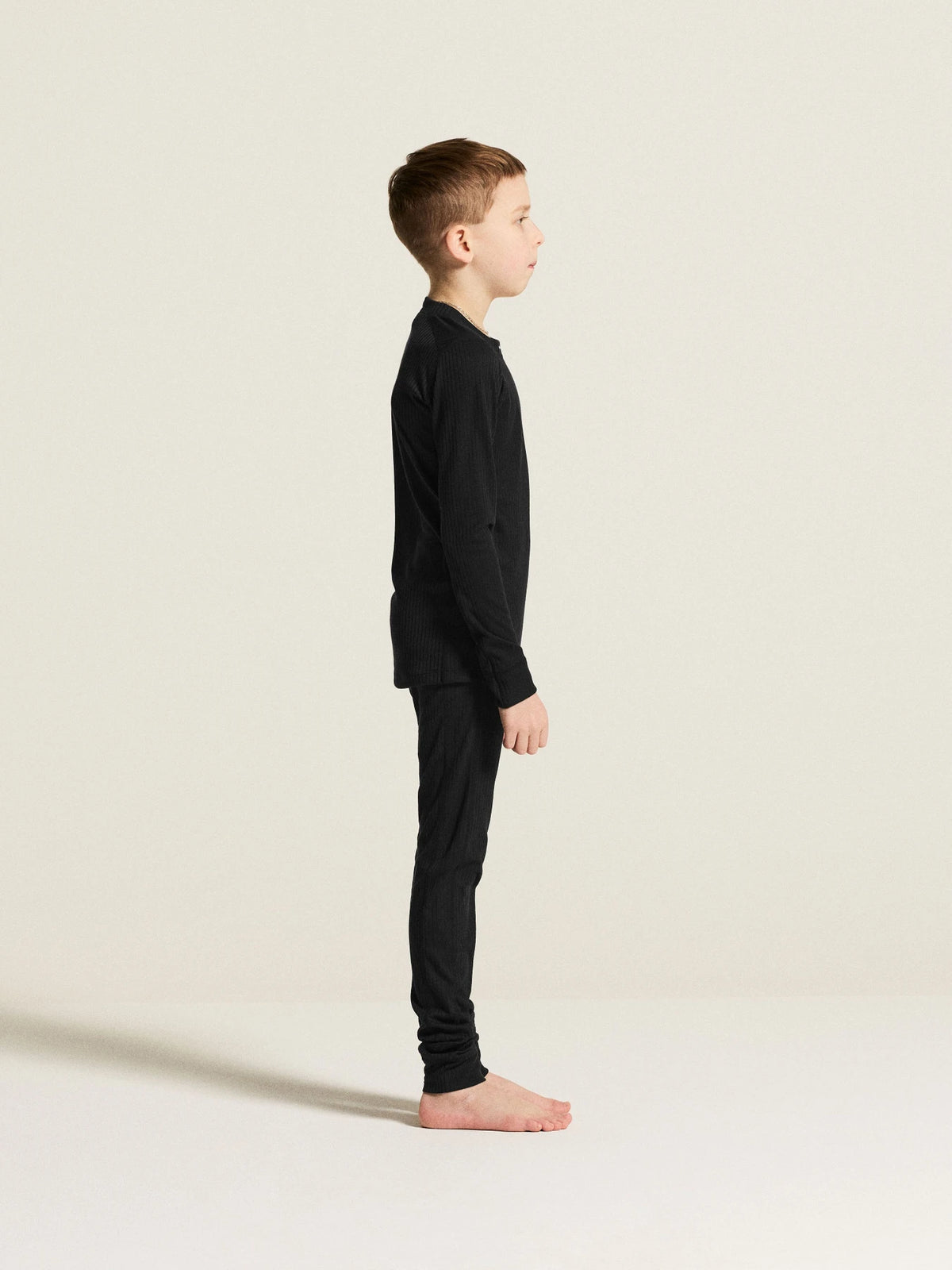 Zwart | zij | Zijaanzicht op model, zwart – Craft thermoset kinderen shirt en broek - Baselayer Set 2