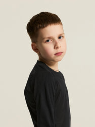Zwart | sfeer | Op model, zijwaarts kijkend, zwart – Craft thermoset kinderen shirt en broek - Baselayer Set 2